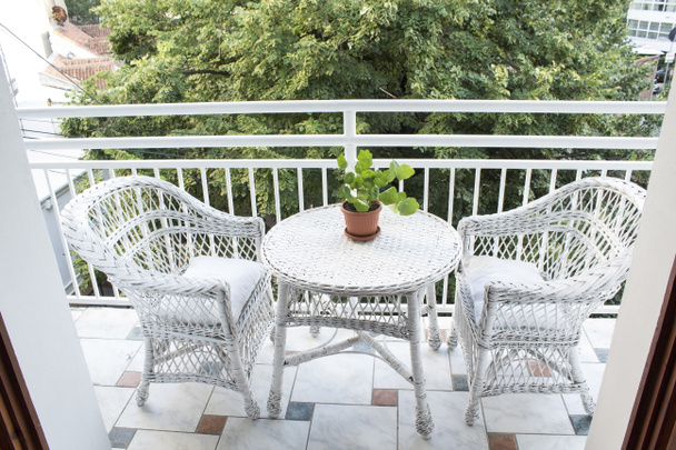 Terraza con Muebles de mimbre y una vista de la copa del árbol
 - Foto, Imagen