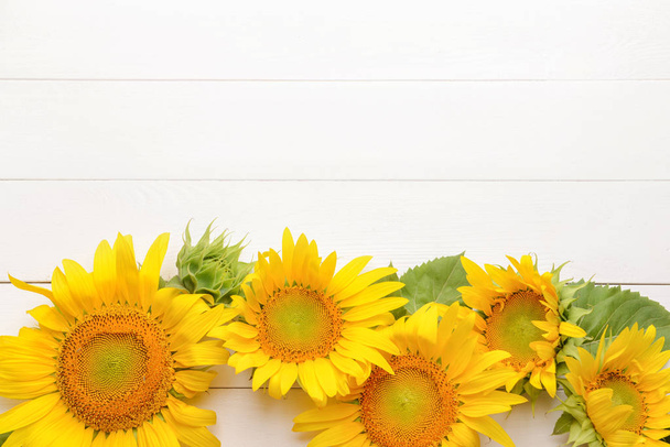 Krásné slunečnice na bílém dřevěném pozadí - Fotografie, Obrázek