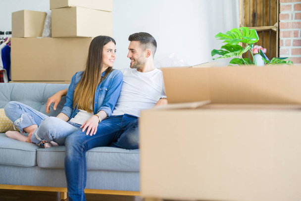 Jeune couple amoureux relaxant assis sur le canapé de la nouvelle maison, souriant heureux de déménager dans un nouvel appartement
 - Photo, image