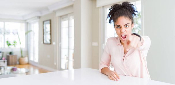 Wide angle of beautiful african american woman with afro hair pointing displeased and frustrated to the camera, angry and furious with you - Fotó, kép