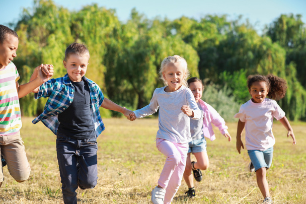 Juoksevien lasten ryhmä puistossa
 - Valokuva, kuva
