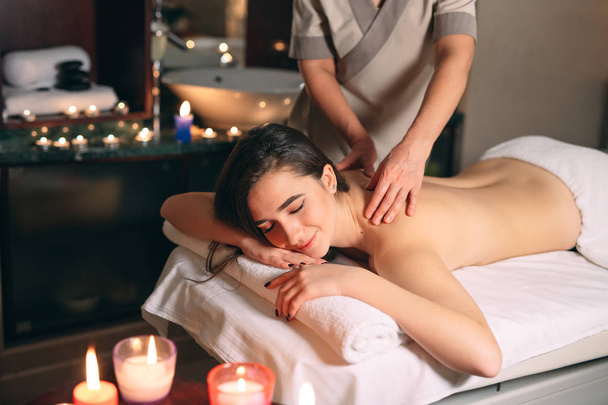 Wellness, Massage. Junge dunkelhaarige schöne Mädchen tun Massage. - Foto, Bild