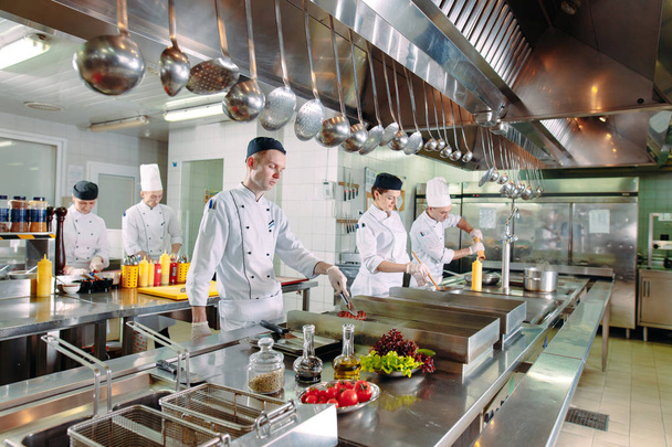 Modern kitchen. The chefs prepare meals in the restaurants kitchen - Фото, изображение