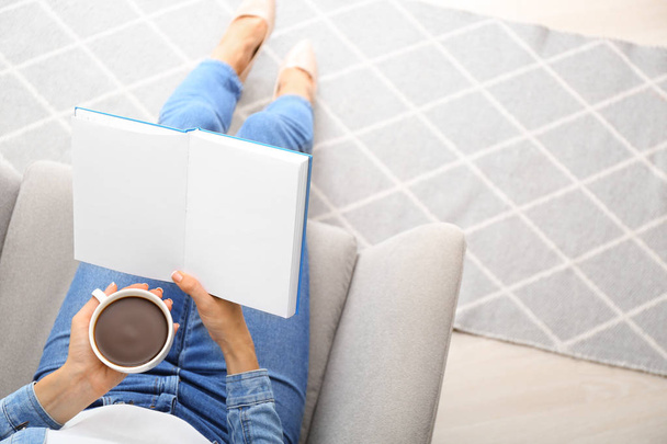 自宅で本を読みながらコーヒーを飲む女性 - 写真・画像