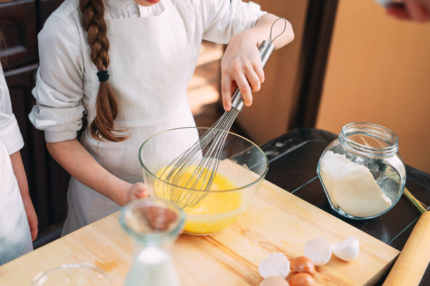 funny girls kids are preparing the dough in the kitchen. - Foto, Bild