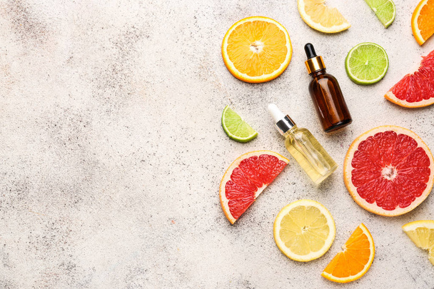 Citrus essential oil on grey background - Foto, imagen