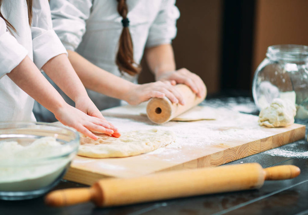 funny girls kids are preparing the dough in the kitchen. - Fotó, kép