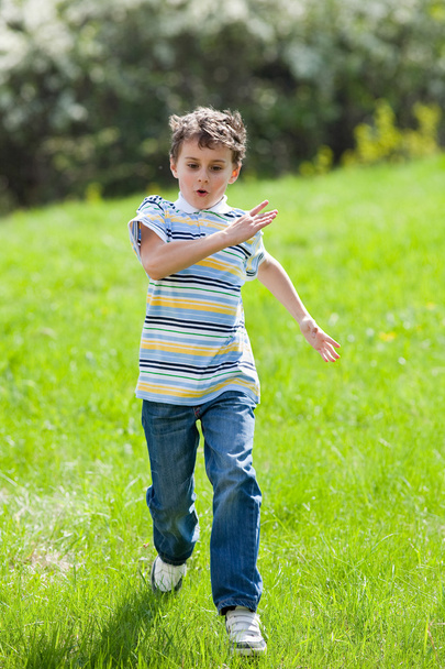 Caucasian child running on grass - Foto, Imagen