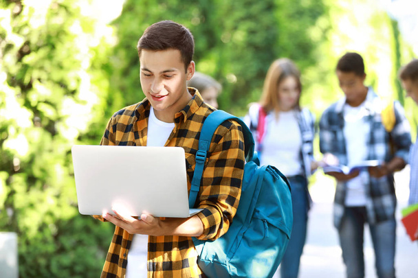 Estudiante joven con portátil al aire libre
 - Foto, imagen