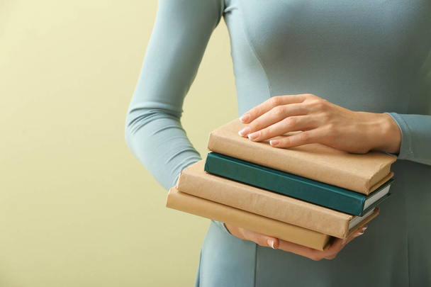Женщина с книгами на цветном фоне, крупным планом
 - Фото, изображение