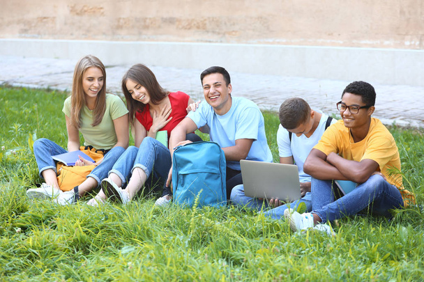 Portrait de jeunes étudiants assis sur l'herbe à l'extérieur
 - Photo, image