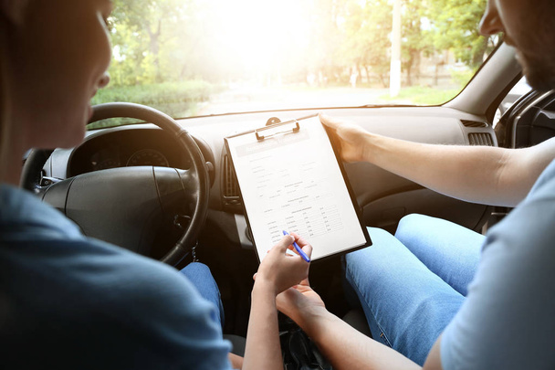 Водитель и страховой агент подписывают договор, сидя в машине
 - Фото, изображение