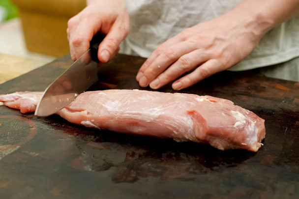 Cutting piece of pork meat on the table. Raw pork. - Photo, Image