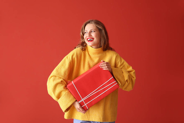 Onnellinen nuori nainen joululahja värillä taustalla
 - Valokuva, kuva