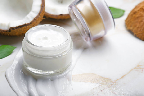 Jars of body cream and coconut on light background - Foto, immagini