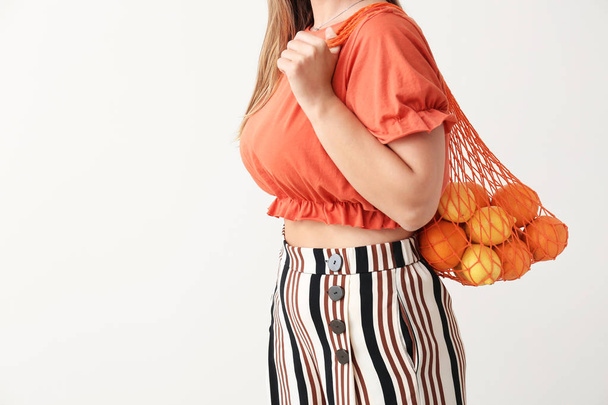 Žena, která drží na pozadí lehký sáček s ovocem - Fotografie, Obrázek