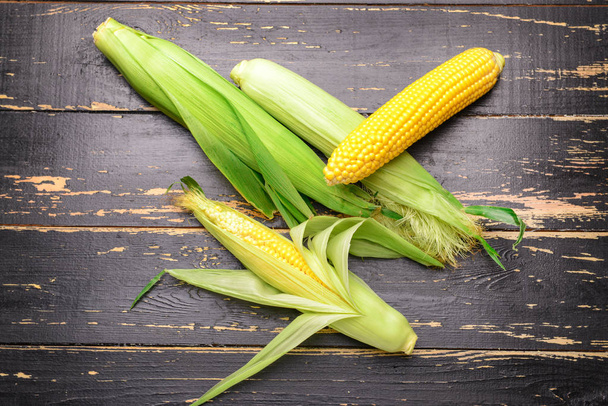 Fresh corn cobs on wooden background - Valokuva, kuva