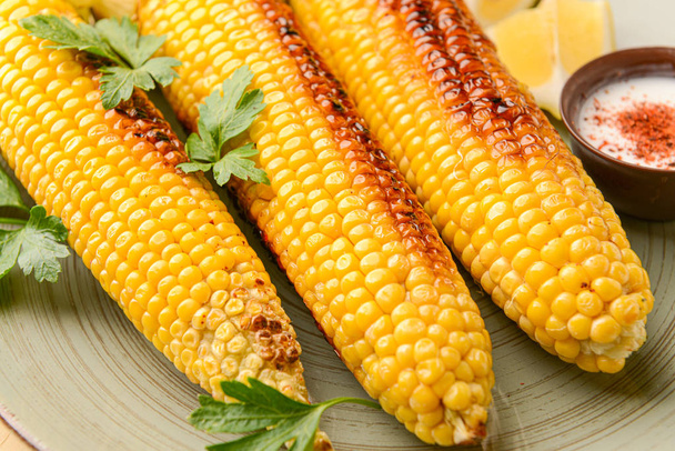 Sabrosas mazorcas de maíz a la parrilla en el plato, primer plano
 - Foto, imagen