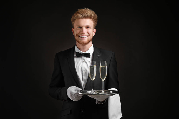 Knappe ober met Champagne op donkere achtergrond - Foto, afbeelding