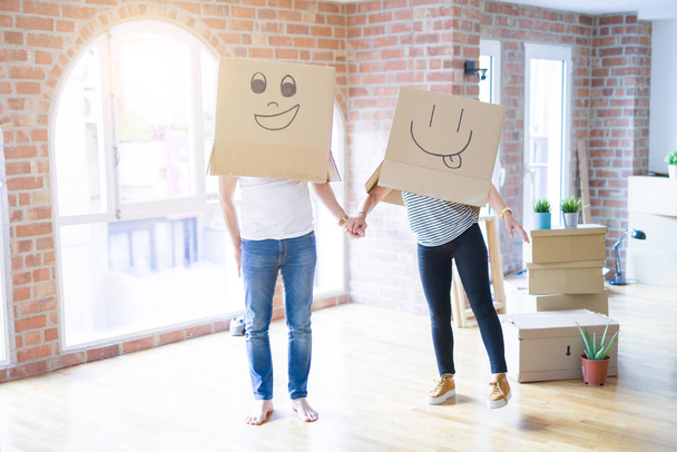 Pareja con divertidas cajas de cartón con caras felices
 - Foto, Imagen