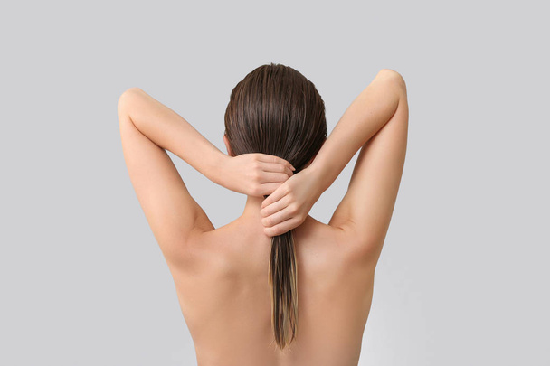 Mulher bonita após lavar o cabelo contra fundo cinza, visão traseira
 - Foto, Imagem