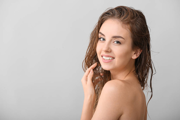 Красива молода жінка після миття волосся на сірому фоні
 - Фото, зображення