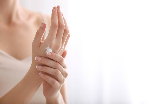 Young woman applying natural cream onto skin at home - Photo, Image