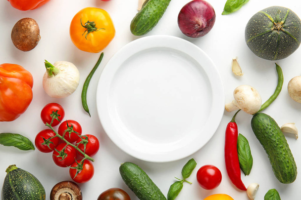 Different fresh vegetables and plate on white background - Φωτογραφία, εικόνα