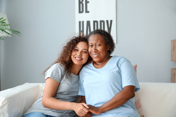 Portret van Afro-Amerikaanse vrouw met haar dochter thuis - Foto, afbeelding
