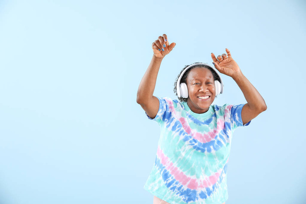 Portrét afroameričanky poslouchající hudbu a tanec proti barevnému pozadí - Fotografie, Obrázek