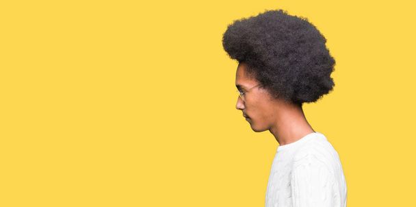 Młody człowiek african american z afro włosów w okularach patrząc w bok, zrelaksować się poza profil z naturalną twarz uśmiech i pewność siebie. - Zdjęcie, obraz