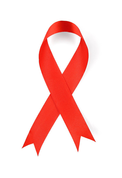 Red satin ribbon on white background. AID awareness concept - 写真・画像