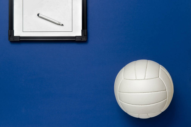 Volleybal en tactisch bord met marker op blauwe achtergrond. Top View - Foto, afbeelding