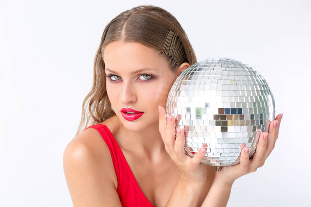 Fashionable young woman with disco ball on white background - Fotografie, Obrázek