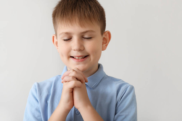 Imádkozó kisfiú a világos háttér - Fotó, kép