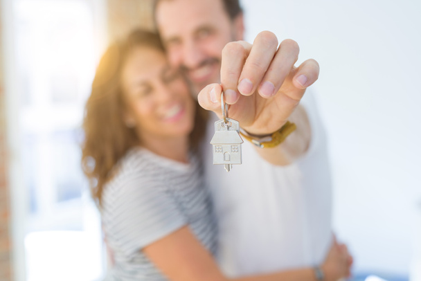 Edad media pareja romántica senior sosteniendo y mostrando las llaves de la casa
 - Foto, Imagen