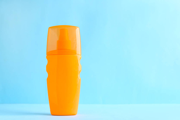 Bottle of sun protection cream on color background - Foto, afbeelding