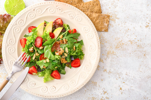 Assiette avec salade fraîche savoureuse sur la table
 - Photo, image