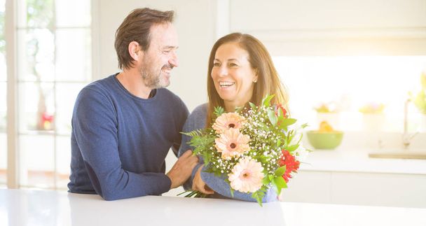 Para romantyczny wieku średniego gospodarstwa kwiaty w miłości w domu - Zdjęcie, obraz