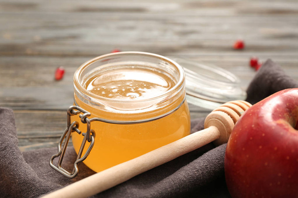 Яр смачного меду, яблука і палички на столі, крупним планом
 - Фото, зображення