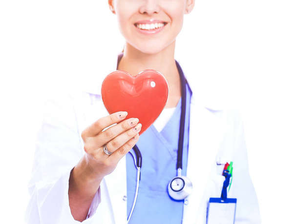 Positive female doctor standing with stethoscope and red heart symbol - Foto, Imagen