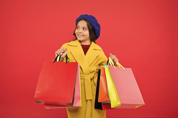 Obsessed with shopping. Girl cute kid hold shopping bags. Get discount shopping on birthday holiday. Nice purchase. Fashionista enjoy shopping. Customer satisfaction. Prime time buy spring clothing - 写真・画像