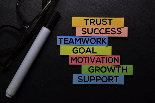 Trust, Success, Teamwork, Goal, Motivation, Growth, Support text on sticky notes isolated on Black desk. Mechanism Strategy Concept - Photo, Image