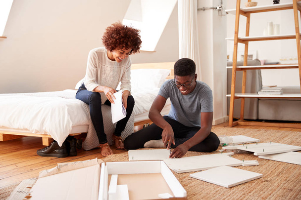 Couple In New Home Putting Together Self Assembly Furniture - Photo, image