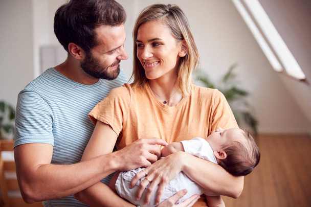 Loving Parents Holding Newborn Baby At Home In Loft Apartment - Foto, imagen