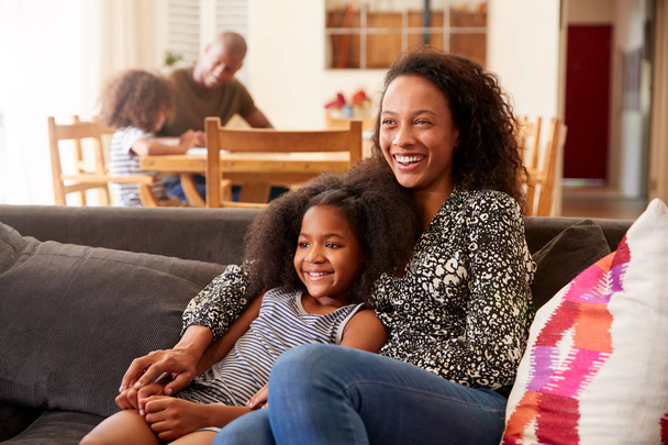 Äiti ja tytär istuu sohvalla kotona katsomassa elokuvaa televisiosta yhdessä
 - Valokuva, kuva