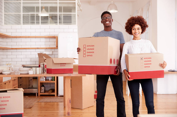 Portrait Of Smiling Couple Carrying Boxes Into New Home On Moving Day - Foto, Imagem
