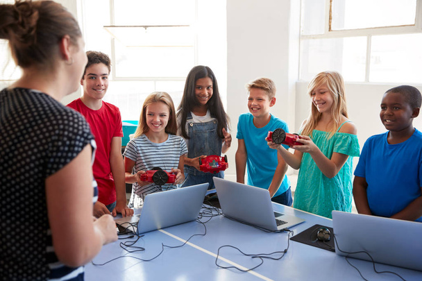 Group Of Students In After School Computer Coding Class Learning To Program Robot Vehicle - Foto, imagen