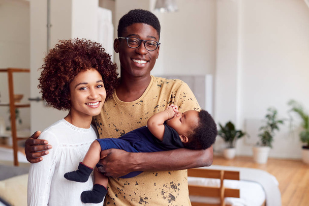 Portrait Of Loving Parents Holding Newborn Baby At Home In Loft Apartment - Photo, Image