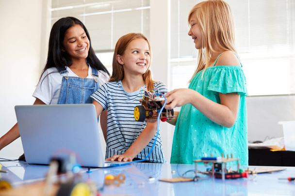 Three Female Students Building And Programing Robot Vehicle In After School Computer Coding Class - Foto, Imagen